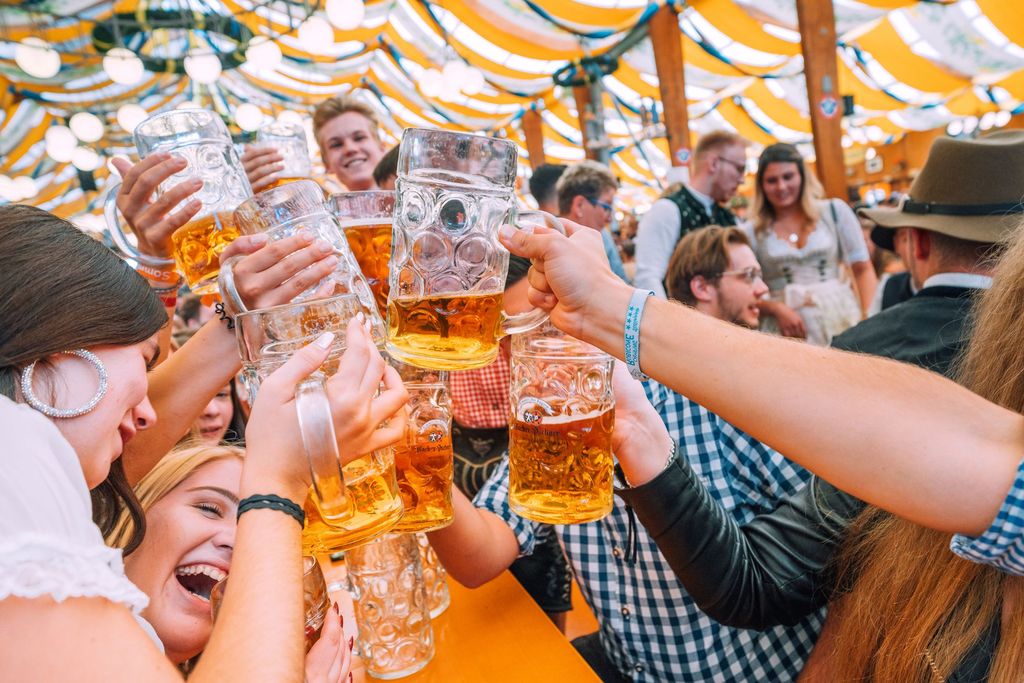Boccali di birra alzati per il brindisi Ein Prosit all'Oktoberfest